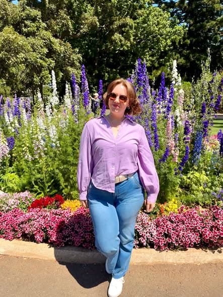 Bec standing among flowering garden beds