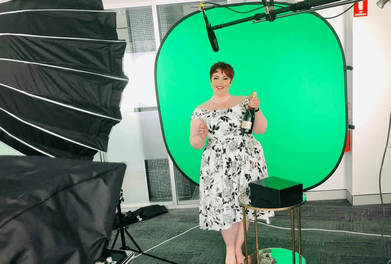 Bec in front of the green screen, lighting and boom microphone used to produce the virtual National Retail Awards