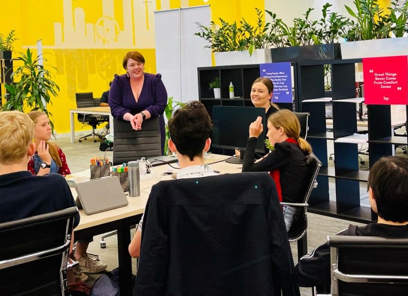 Bec speaking with young entrepreneurs around a table at BOP Industries